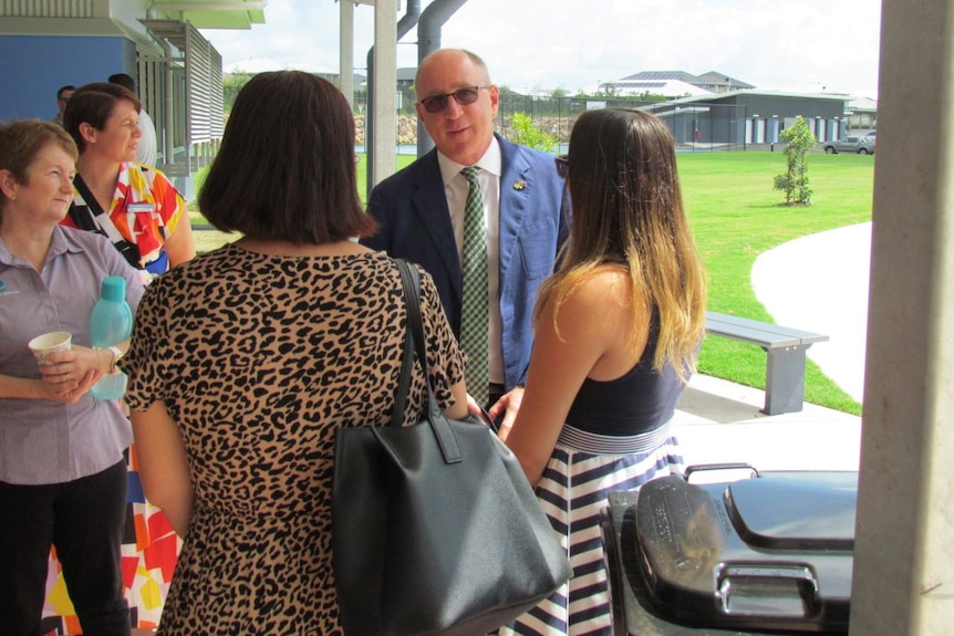 Luke Howarth speaks to a group of people at a school.