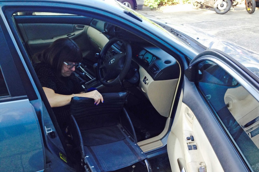 Mel Harrison putting her wheelchair in her car