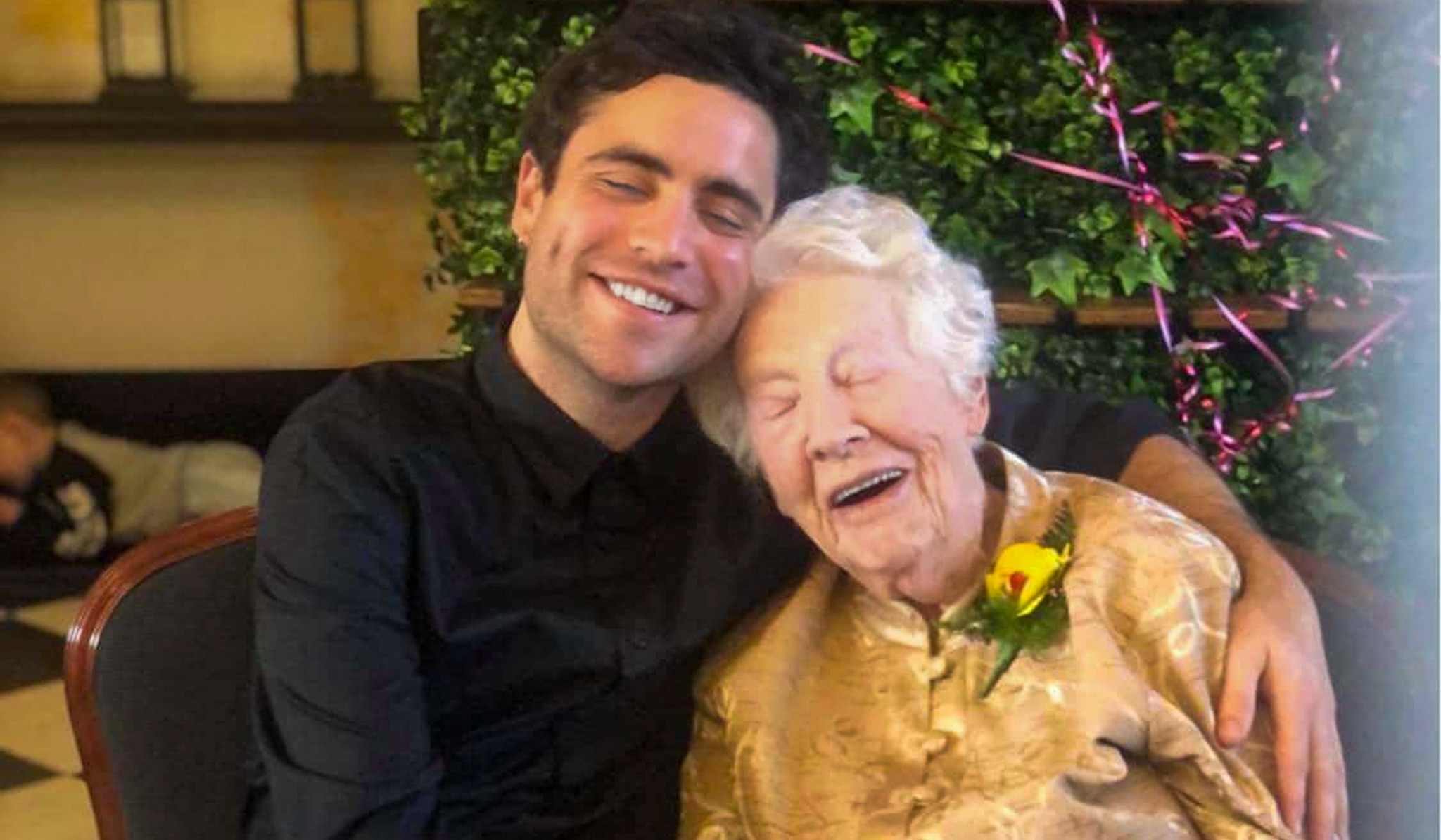 A young man holds his grandmother close