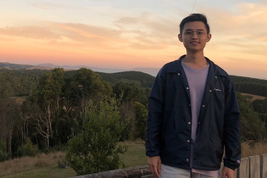 Yunan Lin standing in front of a sunset.