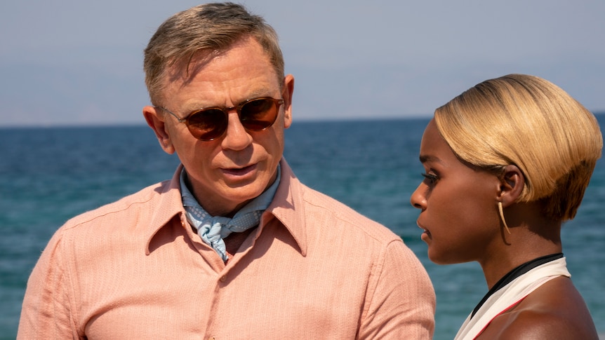 A still image of the film where Daniel wears sunglasses and speaks to Janelle.