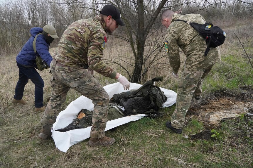 Ukrainian servicemen pack the dead body of a Russian soldier, killed in a recent battle 