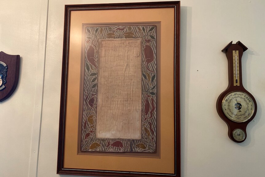 A framed document hanging on a wall.
