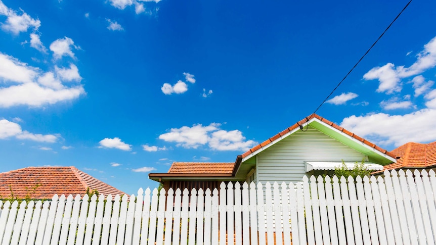 A house behind a white picket fence