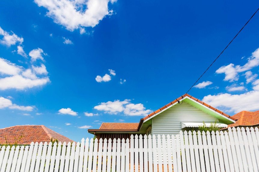 a house behind a white picket fence