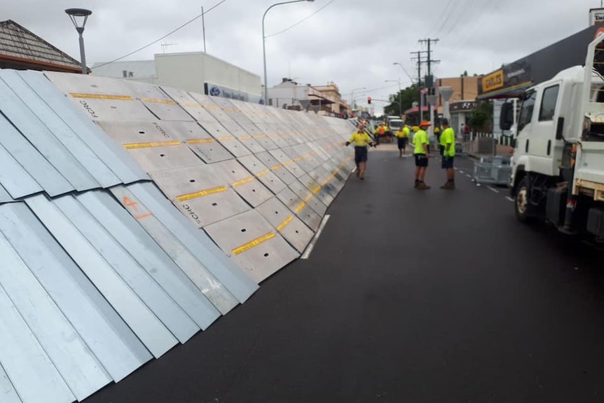 A large flood barrier is built on a city street.