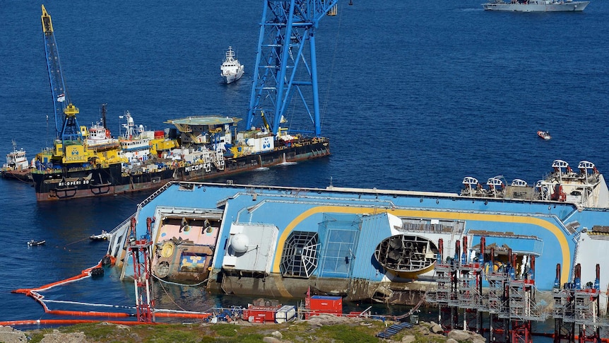 A salvage vessel sits next to the Costa Concordia.