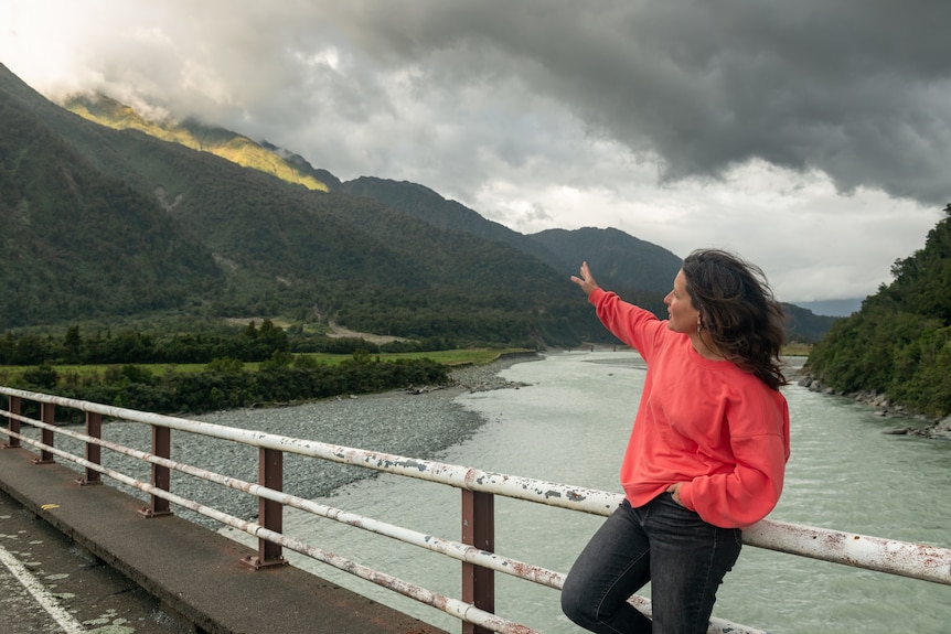 Caroline gestures up to the mountain range where the active fault line is visible 