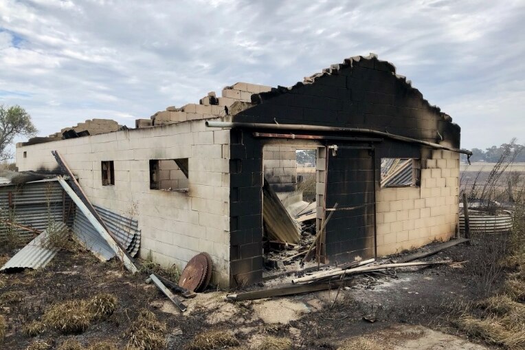 Walls of a fire damaged house and a blackened area of brickwork.