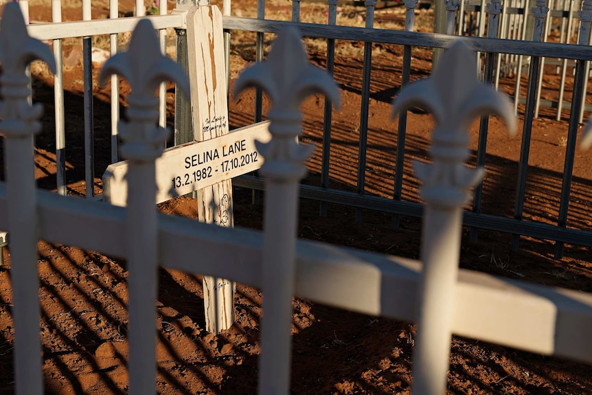 White wright iron fence posts surround the grave of Selina Lane.