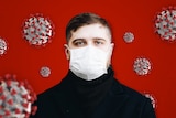 A picture of a man wearing a mask with a red background