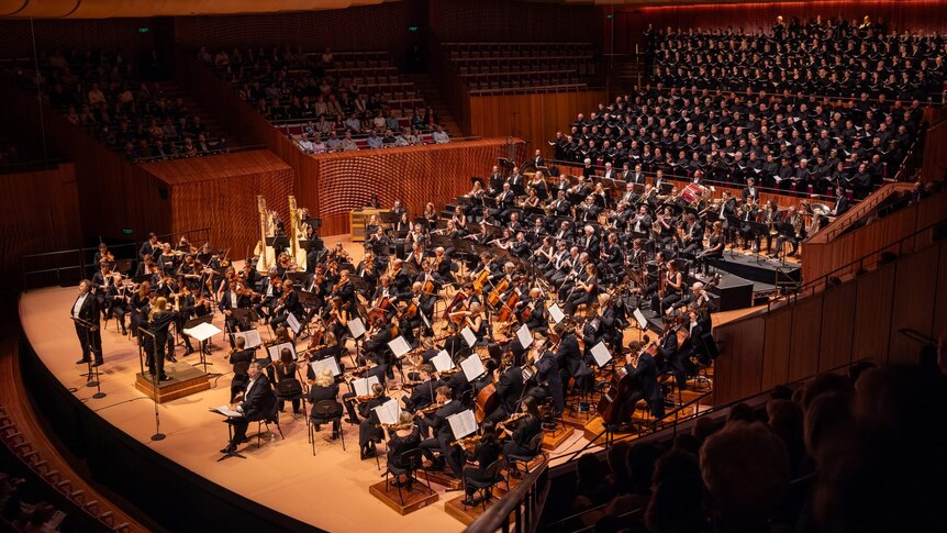 The Concert Hall stage is full of musicians, including two harps and a chorus of 185 singers.