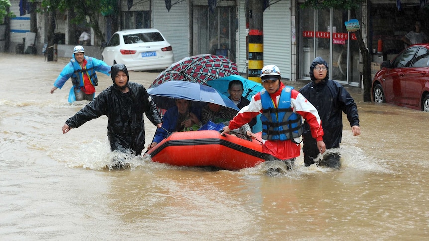 People making their way through flood water brought by Typhoon Chan-hom