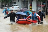 People making their way through flood water brought by Typhoon Chan-hom