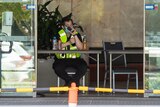 A security guard sits at the entrance to the Four Points Sheraton hotel in Perth talking on a walkie talkie.