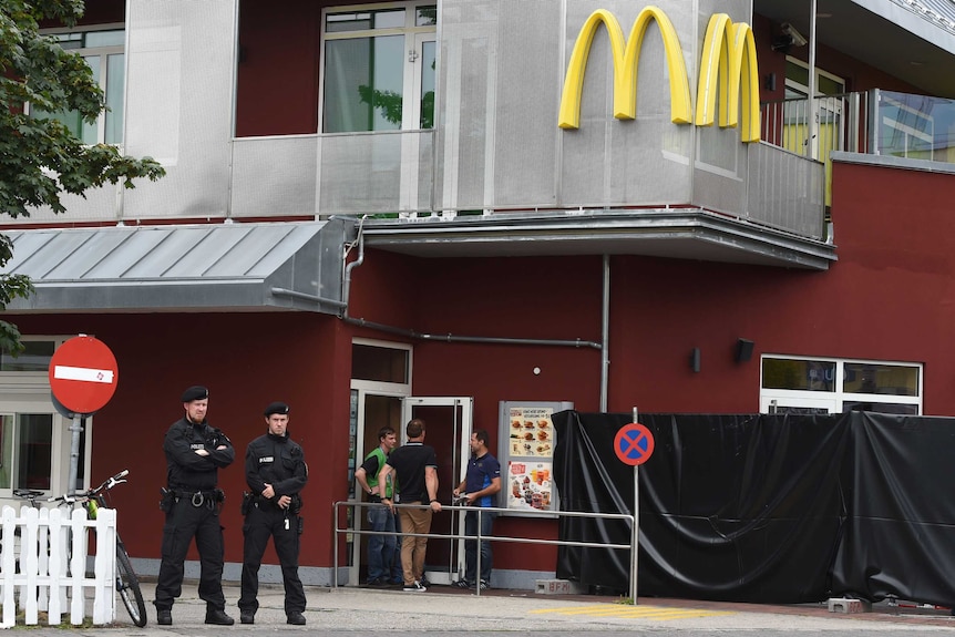Policemen stand in front of a McDonald's restaurant in Munich.