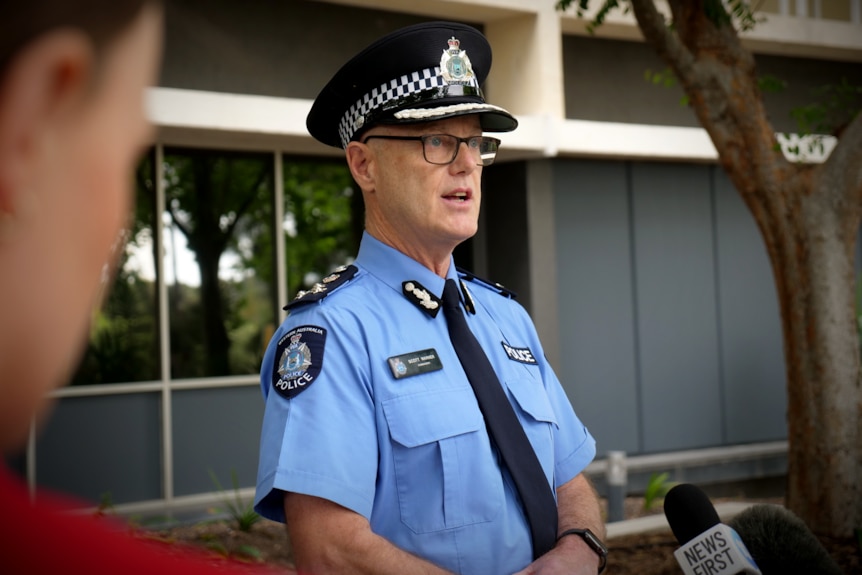 A male police commander outside the WA Police headquarters standing in front of media microphones.