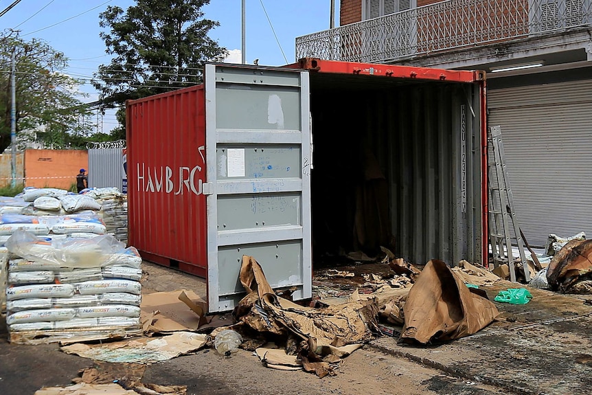 A container sits with it's door open and piles of fertiliser nearby.