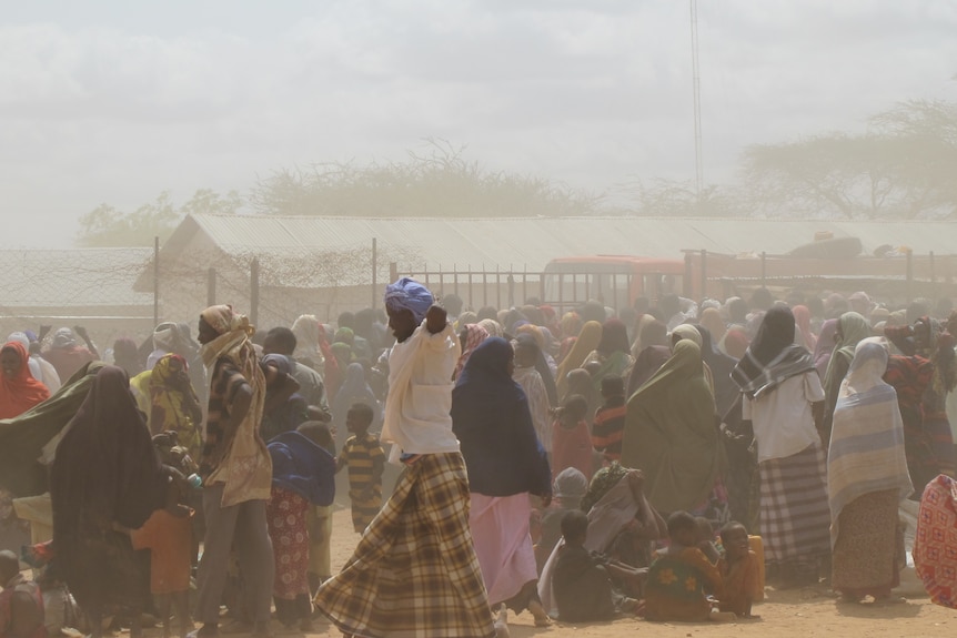 Refugees wait for assistance as a dust storm sweeps across the Dadaab refugee camp in Kenya.