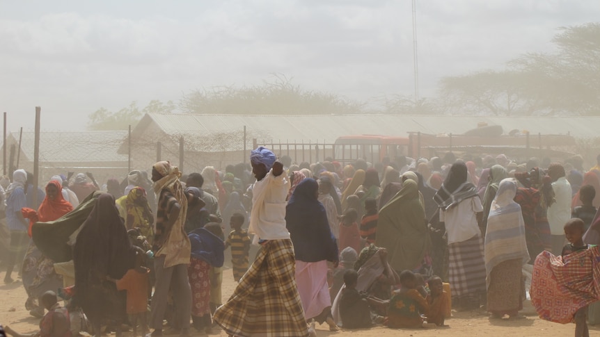 Refugees wait for assistance as a dust storm sweeps across the Dadaab refugee camp in Kenya.
