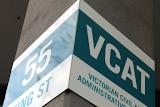 A sign with the words Victorian Civil and Administrative Tribunal hangs on a concrete pillar
