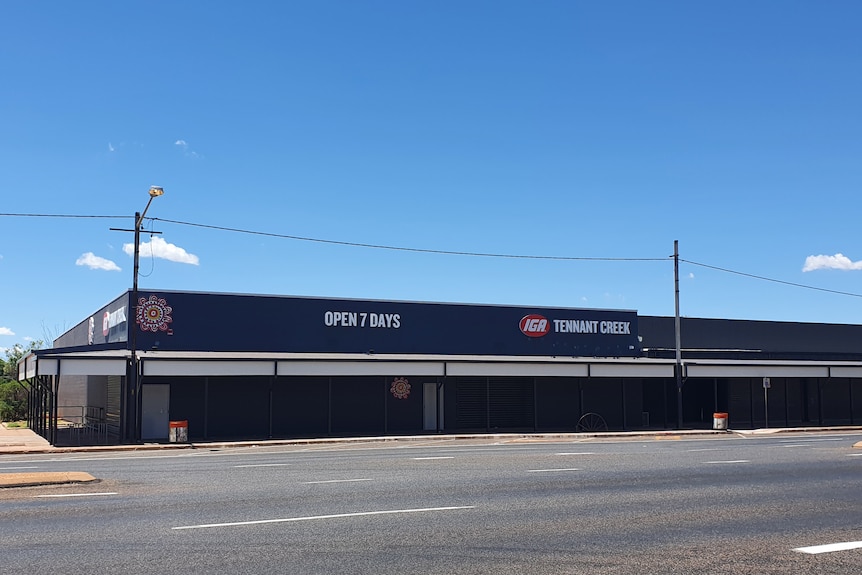 exterior of an IGA supermarket, bitumen road, blue sky