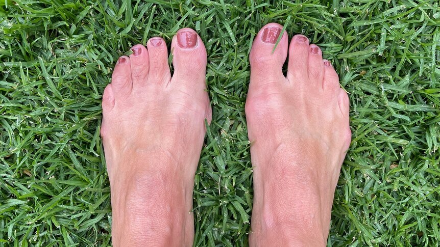 Monica's feet standing on green grass