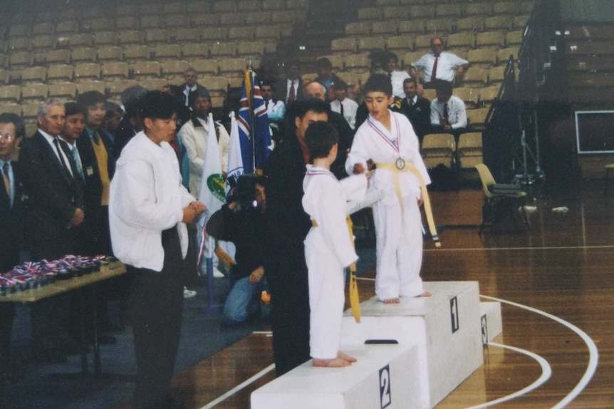 Hayder Shkara receiving a Taekwondo award as a young boy.