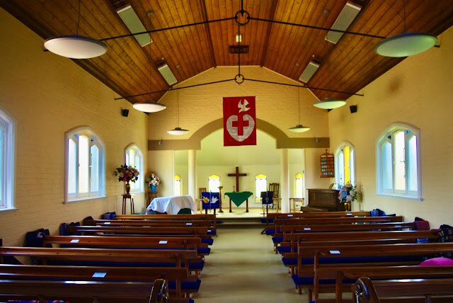 Salón de la iglesia con bancos largos, piano, salón decorado para un servicio religioso cristiano.