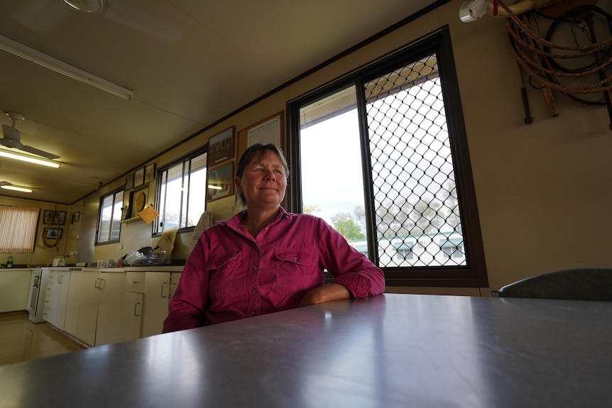 Woman sitting at kitchen table staring into distance