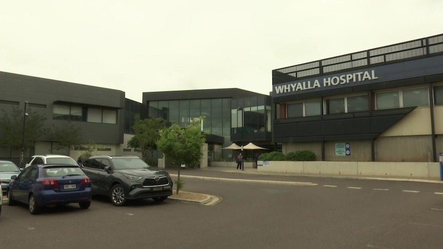 A hospital building with car park out the front