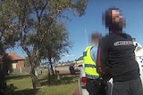 A man being arrested standing by a police van with his face pixellated