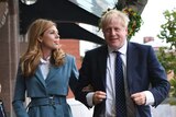 Britain's Prime Minister Boris Johnson walks arm-in-arm with partner Carrie Symonds