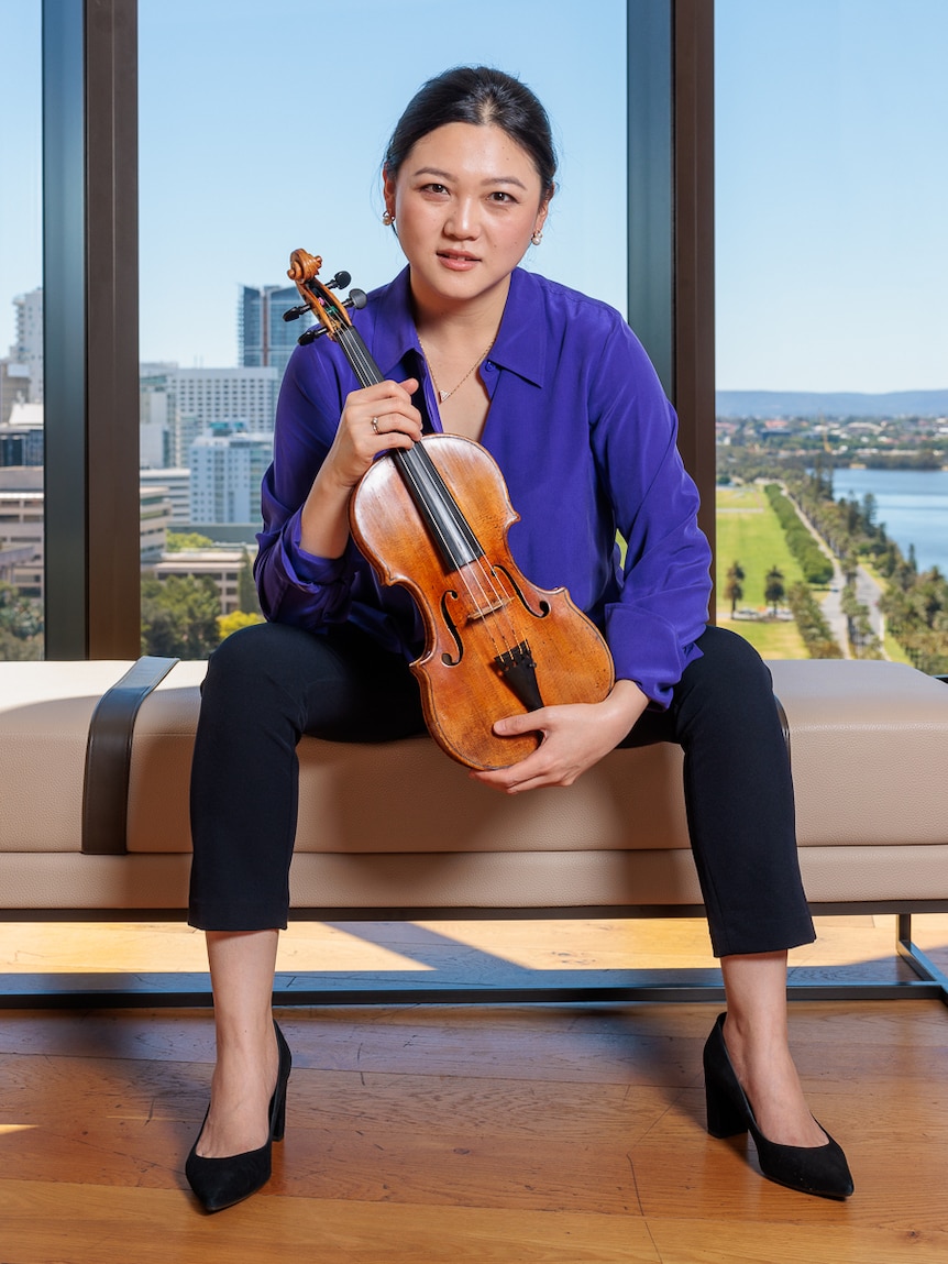 Emily Sun holding the historic "Adelaide" violin. 
