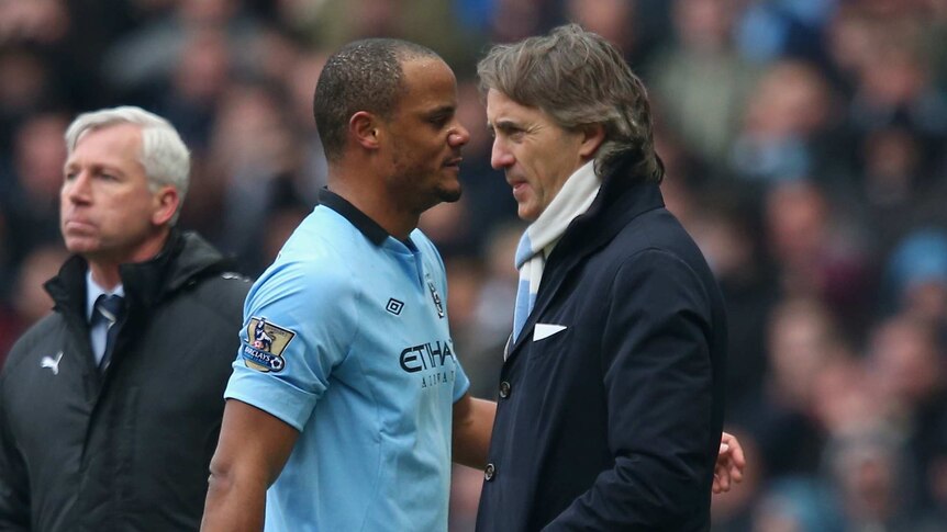 No words ...Vincent Kompany (L) walks past his manager Roberto Mancini after being substituted