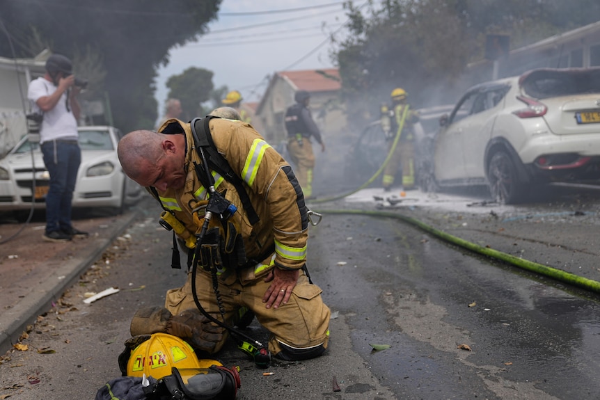 A firefighter kneeling on the ground.
