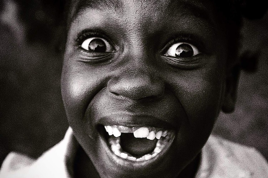 A girl in a refugee camp in the Democratic Republic of Congo smiles.