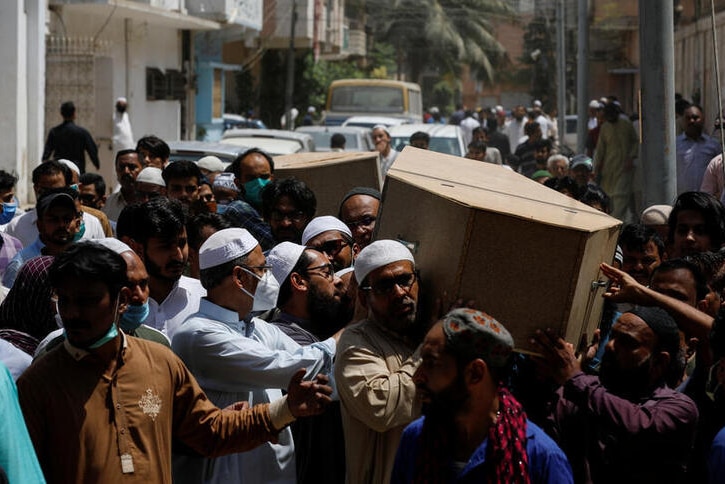 Several men seen carrying a coffin in the streets in Pakistan.