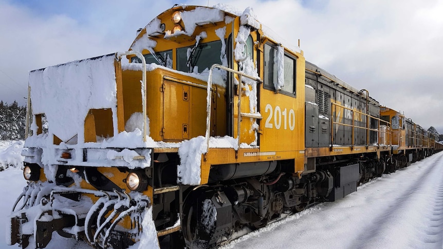 Train locomotive covered in snow.