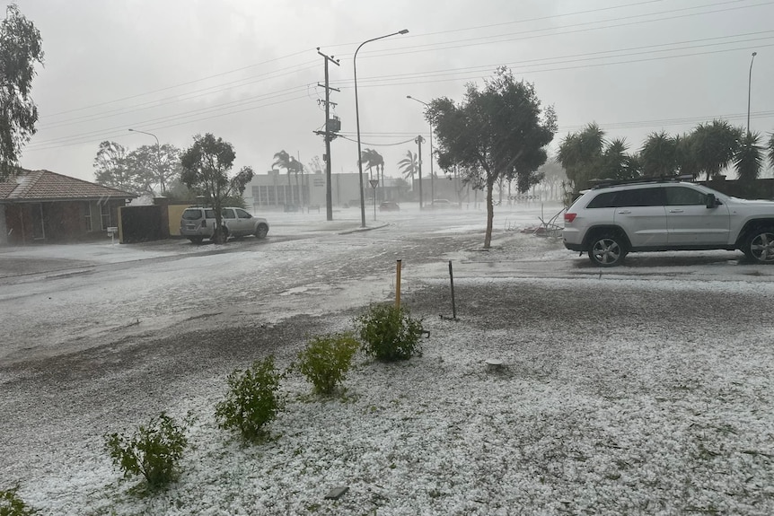 a residential street in a storm, covered in hail