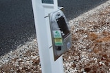 electronic sensor mounted on a white roadside warning post 