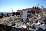 Firefighters stand among the ruins of an orthodox church in Crete after a strong earthquake.