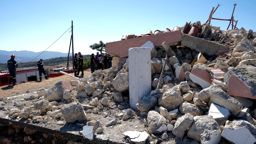 Firefighters stand among the ruins of an orthodox church in Crete after a strong earthquake.