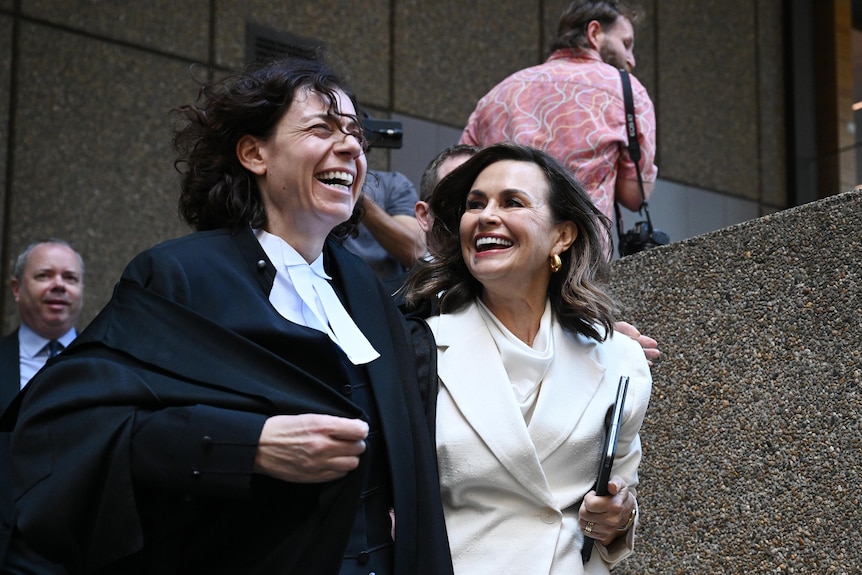 Lisa and Sue smile and walk outside court.