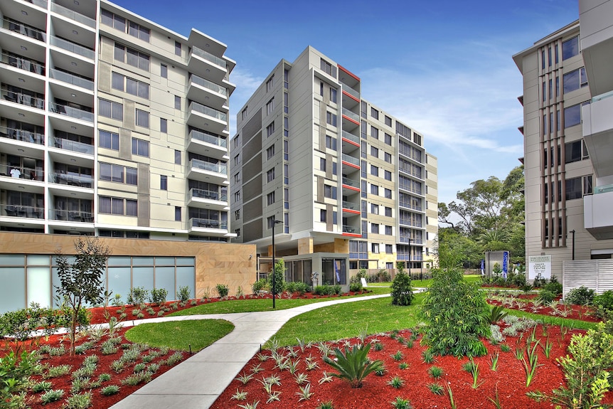 Apartment block buildings with a garden and footpath