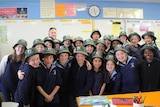 22 primary school students wearing hats with Neighbourhood Watch on them with police officer.