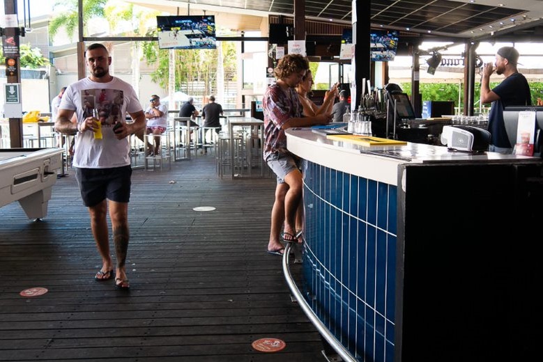 A bar with a handful of people and lots of empty seats.