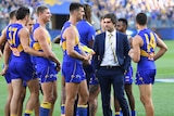 Andrew Gaff dressed in a suit speaks to his West Coast Eagles teammates after they won their AFL preliminary final.