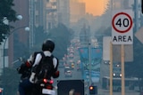 Smoke chokes Perth's CBD as traffic filters down St George's Terrace at sunrise