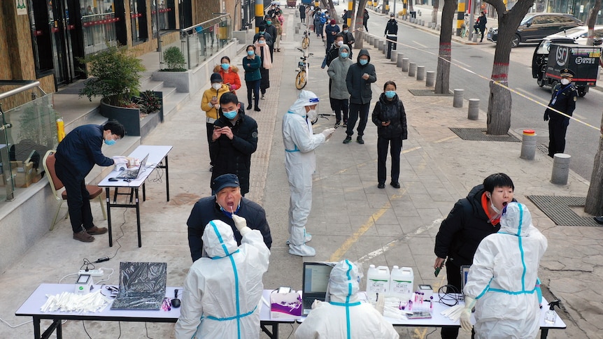  Residents line up for COVID-19 tests at a mobile testing site in Xincheng District of Xi'an.